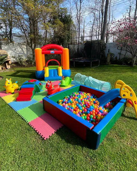Inflable naranjo y gran piscina de pelotas en un jardín primaveral