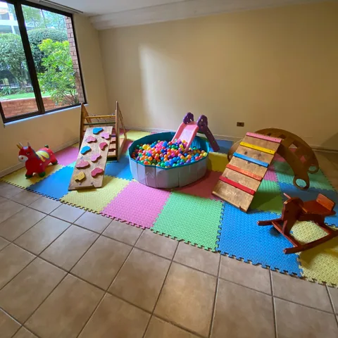 Pack estilo Pikler con rampa de escalada de madera montado en una sala interior